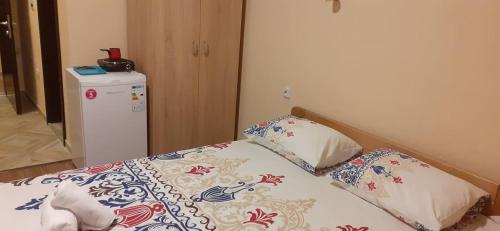 een kleine slaapkamer met een bed en een koelkast bij Sunshine in Gevgelija