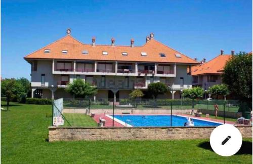 een groot gebouw met een zwembad ervoor bij Bonito Duplex en Gran URB Con PISCINA in Ajo