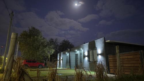 een huis waar 's nachts een auto voor geparkeerd staat bij Casitas Atlántida in Atlántida