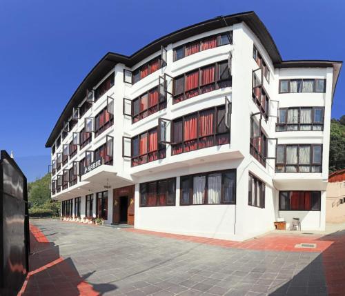 um grande edifício branco com janelas vermelhas em Hotel kabir em Srinagar