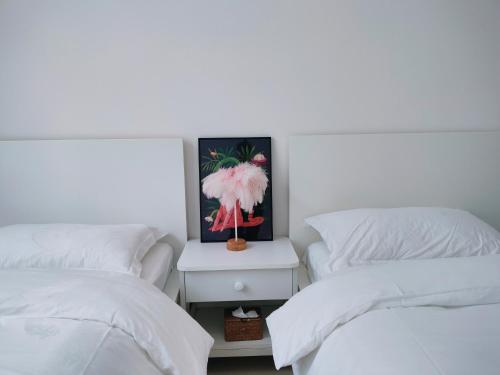 een slaapkamer met 2 bedden en een foto aan de muur bij Lotus Art Inn PEK Airport 菡庭筱院民宿北京首都机场店 in Shunyi