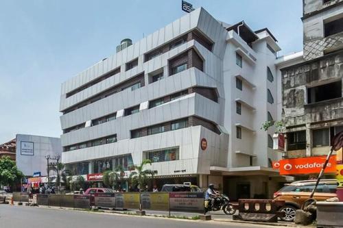 een groot wit gebouw aan de straatkant bij Nexstay Asma Tower in Kozhikode