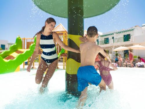 Ein Junge und ein Mädchen spielen in einem Wasserpark in der Unterkunft MYND Yaiza in Playa Blanca