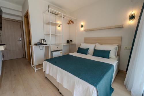 um quarto com uma cama grande e um cobertor azul em Mia Hill Suites em Bodrum City