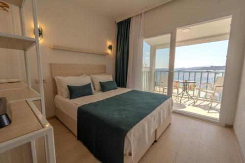 um quarto com uma cama grande e uma varanda em Mia Hill Suites em Bodrum City