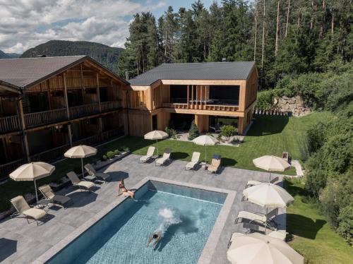 una vista aérea de una casa con piscina en Dolmites Nature Hotel Vigilerhof, en Siusi