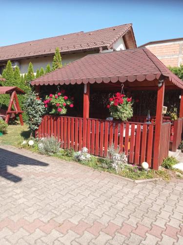 une maison avec une clôture rouge et un bâtiment avec des fleurs dans l'établissement Casa Judith, à Turda