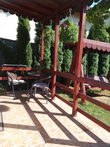 une pergola en bois avec des tables et des chaises sur une terrasse dans l'établissement Casa Judith, à Turda