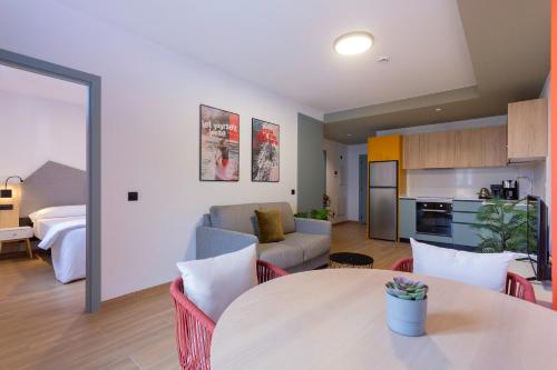 cocina y sala de estar con mesa y sofá en Sholeo Lodges Las Palmas Flats, en Las Palmas de Gran Canaria