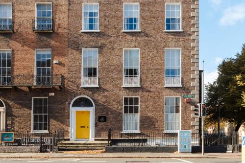 een rood bakstenen gebouw met een gele deur bij Sonder The Earl in Dublin