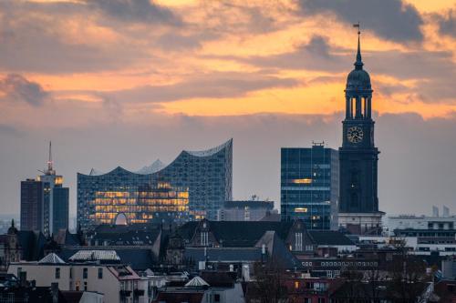 Mövenpick Hotel Hamburg City في هامبورغ: أفق المدينة مع برج الساعة والمباني