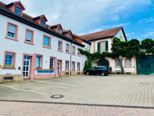 une voiture garée dans un parking à côté d'un bâtiment dans l'établissement Ferienwohnungen Deidesheim, à Deidesheim