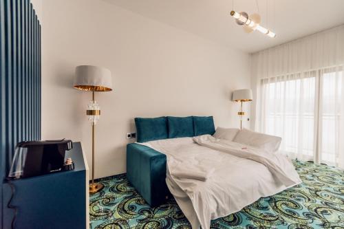 a bedroom with a bed with a blue head board at Villa Galleria in Colibiţa