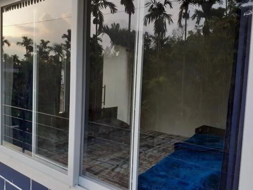 a screened in porch with a view of palm trees at Saaranga homestay in Avathi