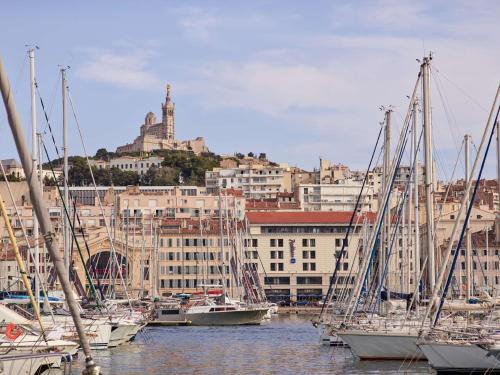 grupa łodzi zakotwiczona w porcie z miastem w obiekcie Radisson Blu Hotel Marseille Vieux Port w Marsylii