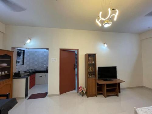 a room with a kitchen with a desk and a television at V4 Stay - Luxury 1 BHK AC Suite sleeps 5 guests in Coimbatore