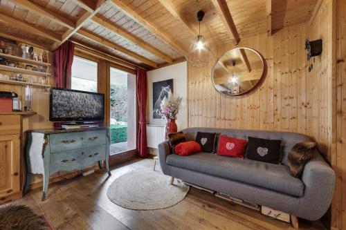 een woonkamer met een bank en een televisie bij Appartement chaleureux au Chalet Barme de l'Ours 2 in Val dʼIsère