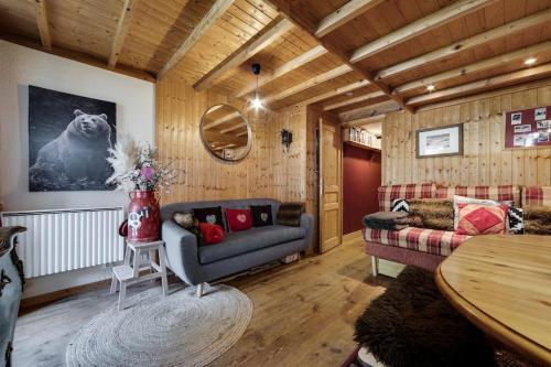 een woonkamer met een bank en een tafel bij Appartement chaleureux au Chalet Barme de l'Ours 2 in Val dʼIsère