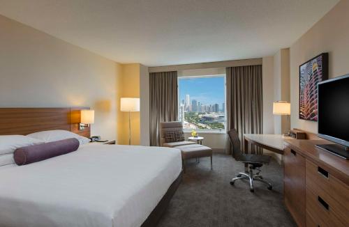 een hotelkamer met een bed, een bureau en een televisie bij Hyatt Regency McCormick Place Chicago in Chicago