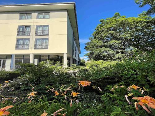 Un bâtiment avec beaucoup de fleurs devant lui dans l'établissement Mercure Hotel Gera City, à Gera