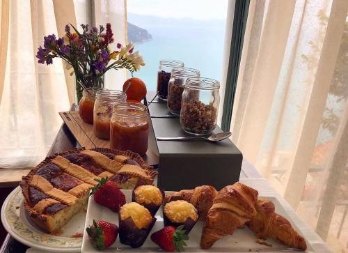 een tafel met een bord brood, zoete deegwaren en fruit bij Garden Hotel in Ravello