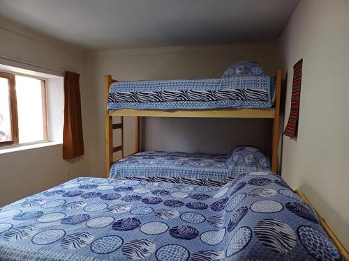 - une chambre avec des lits superposés et une couette bleue dans l'établissement La Maison de Frida, à Cusco