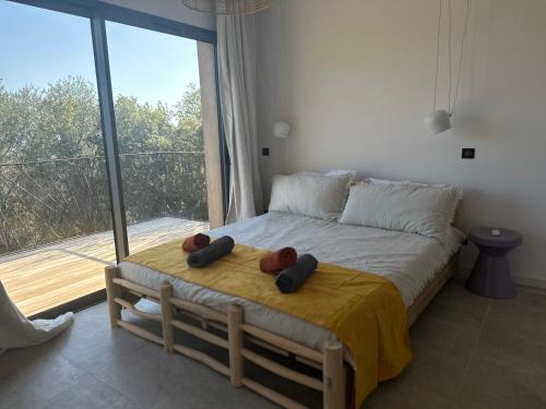 1 dormitorio con 1 cama y ventana grande en Casaty Mare, en Porto Vecchio