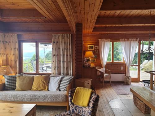 - un salon avec un canapé et quelques fenêtres dans l'établissement Mont Blanc Chalet, à Grandevent