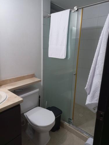 a bathroom with a toilet and a glass shower at Apartamento hogareño in Pereira