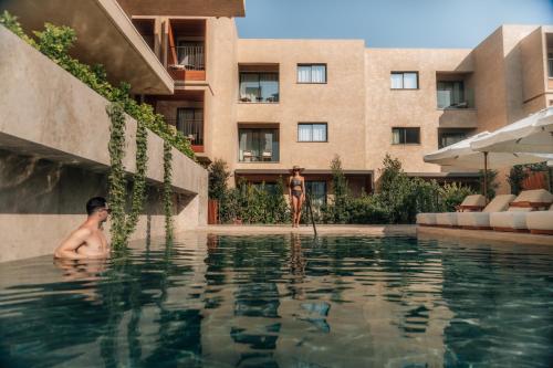 two men in the swimming pool at a hotel at M Boutique Hotel - Designed for Adults in Paphos City