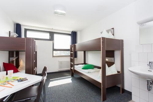 een kamer met 2 stapelbedden en een wastafel bij Jugendherberge City-Hostel Köln-Riehl in Keulen