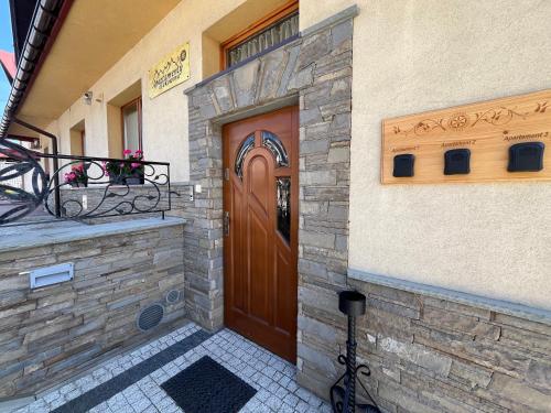 una casa con porta in legno e balcone di Apartamenty Bukowina a Bukowina Tatrzańska