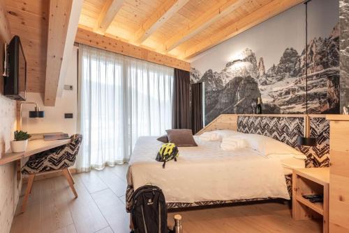 een slaapkamer met een bed met een rugzak erop bij Hotel La Perla in Andalo