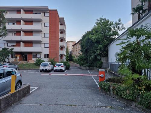 ein Parkplatz mit Autos vor einem Gebäude in der Unterkunft Confortevole appartamento nel cuore di Lugano in Lugano