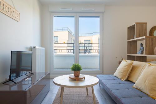 a living room with a blue couch and a tv at Le Péruvien - Saint-Cyr-L'Ecole - Free Parking in Saint-Cyr-lʼÉcole