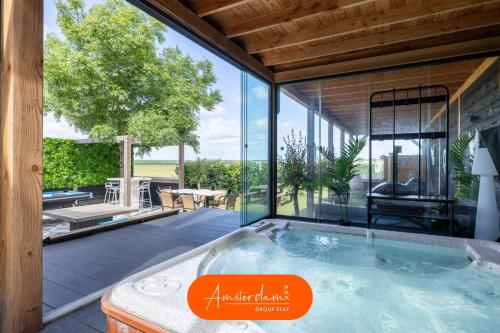 an indoor hot tub in a house with a patio at 10 min to Amsterdam! 26 beds, Jacuzzi's, & Disco! in Zwanenburg