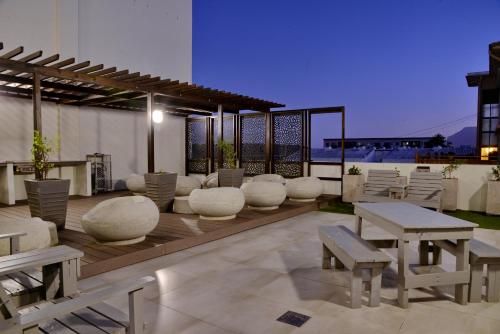 un patio con mesas y sillas en la azotea en WINK Aparthotel Eaton Square, en Ciudad del Cabo