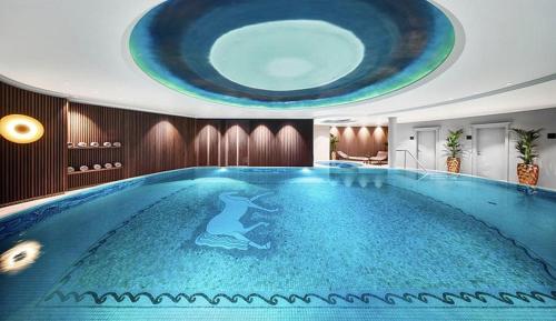 een groot zwembad met een dolfijn erop geschilderd bij KITZ DELUXE SUITE 1 & 2 im Zentrum mit POOL, eigenem SPA & PARKEN by belle-stay in Kitzbühel