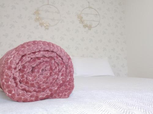 een roze hoed op een bed bij Precioso apartamento en el centro recién reformado in Santander