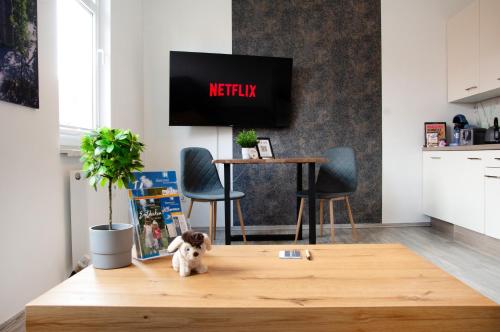 een hond zittend op een houten tafel in een woonkamer bij Ilmpartment Deluxe Suite - Vollausstattung - Boxspringbett - Wi-Fi - Netflix in Ilmenau