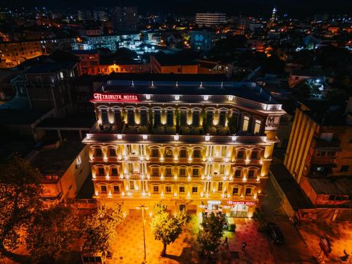 a building lit up at night with lights at TRIBUTE Hotel in Shkodër