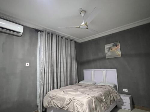 Schlafzimmer mit einem Bett und einem Deckenventilator in der Unterkunft Cozy Haven Suite in Accra