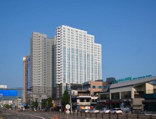 una ciudad con edificios altos y coches en una calle en The Hotel Sokcho by Best Western Signature Collection, en Sokcho