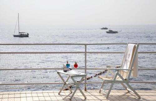 a table and two chairs on a balcony overlooking the water at Ravello Art Hotel Marmorata in Ravello