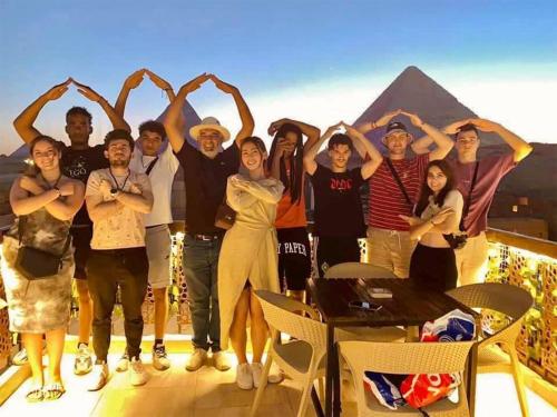 un grupo de personas posando para una foto frente a las pirámides en Comfort Sphinx&Pyramids Inn en El Cairo