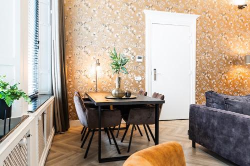 a dining room with a table and chairs and a couch at Luxious Apartment Wilhelmina in Tilburg