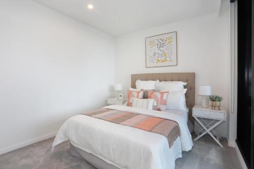 Rúm í herbergi á REST COLLECTION Apartment at SkyGarden Glen Waverley