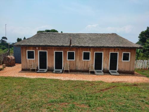 ein kleines Gebäude mit Stühlen davor in der Unterkunft Thatched Cottage Suites in Jinja