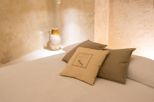 un letto con due cuscini e un vaso sopra di Il Suq Lecce Luxury Apartment a Lecce