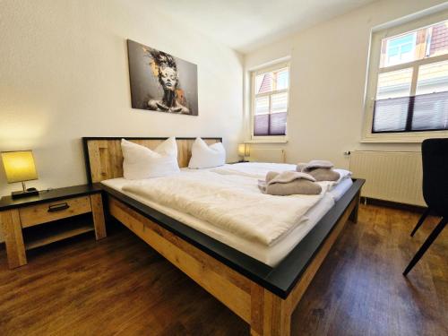 sypialnia z dużym łóżkiem z białą pościelą w obiekcie DM Hotels & Apartments - Apartment Brückenstr 27 w mieście Mühlhausen